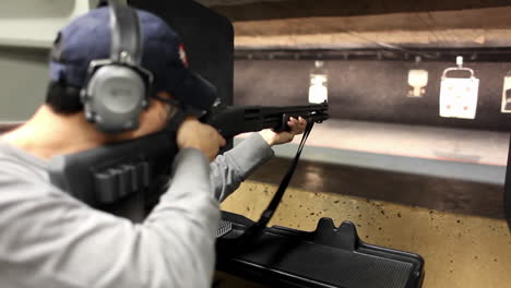 a man fires a rifle at a target at an indoor shooting range 1