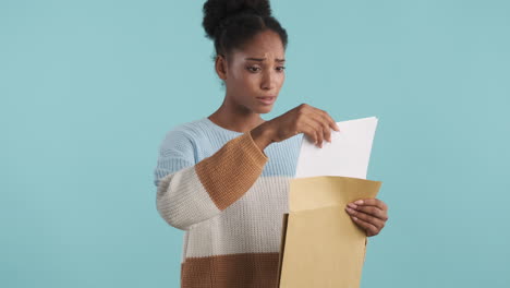 unhappy woman opening envelope