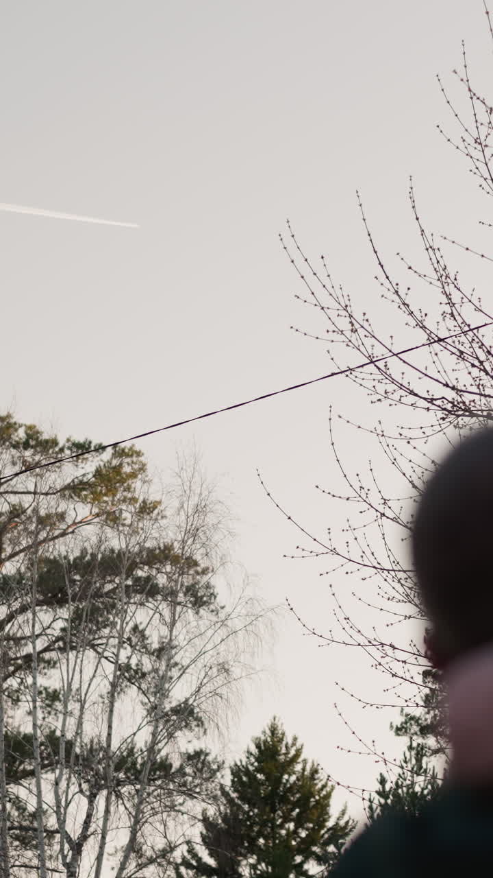 초록색 재을 입은 남자가 핑크색 재과 맞춤형 베니를 입은 딸을 들고 다니며, 두 사람이 하늘을 쳐다보면서 그녀의 머리가 그의 머리에 부드럽게 혀 있습니다.