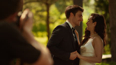 novia y novio mostrando anillos al aire libre