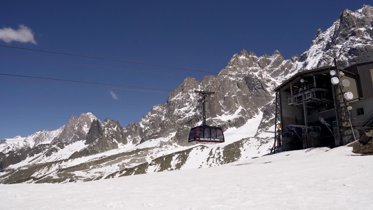 AIGUILLE DU MIDI CHAMONIX MONT BLANC, FRANCE on JUNE 2019. The cable car cabin arrives at the station high in the snowy mountains on a sunny day. alpes mountain aiguille du midi