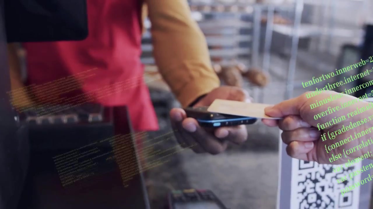 Buyer tapping card, staff holding reader in bakery, code overlay flowing over hands processing sale