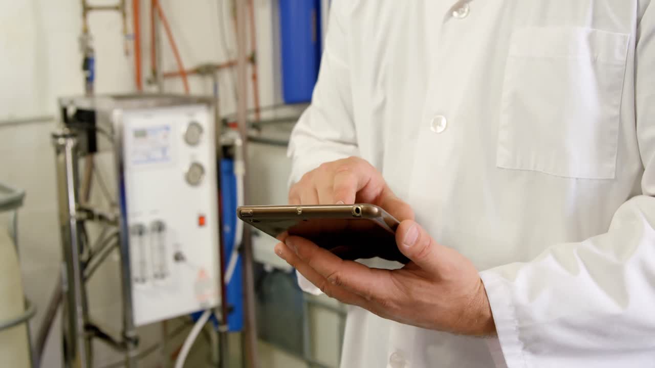 trabajador masculino que usa una tableta digital en una fábrica 4k