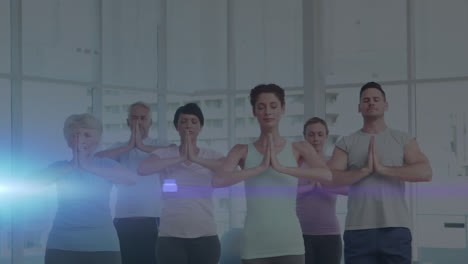 Animation-of-glowing-light-over-people-practicing-yoga