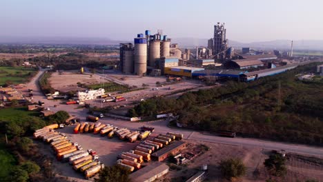 kjs cement factory with parked vehicles and trees at girgita, madhya pradesh, india. day time, pan shot, drone shot, 4k.