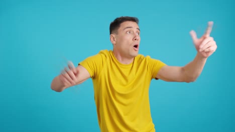 man expressing surprise and joy in front of blue background