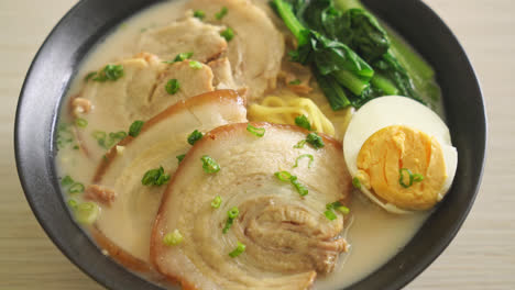 ramen noodles in pork bone soup with roast pork and egg or tonkotsu ramen noodles - japanese food style