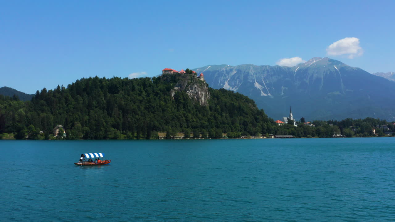 Barcaio che Rema su una Tradizionale Barca Pletna con Turisti nel Lago di Bled - Gita in Barca all'Isola di Bled in Slovenia