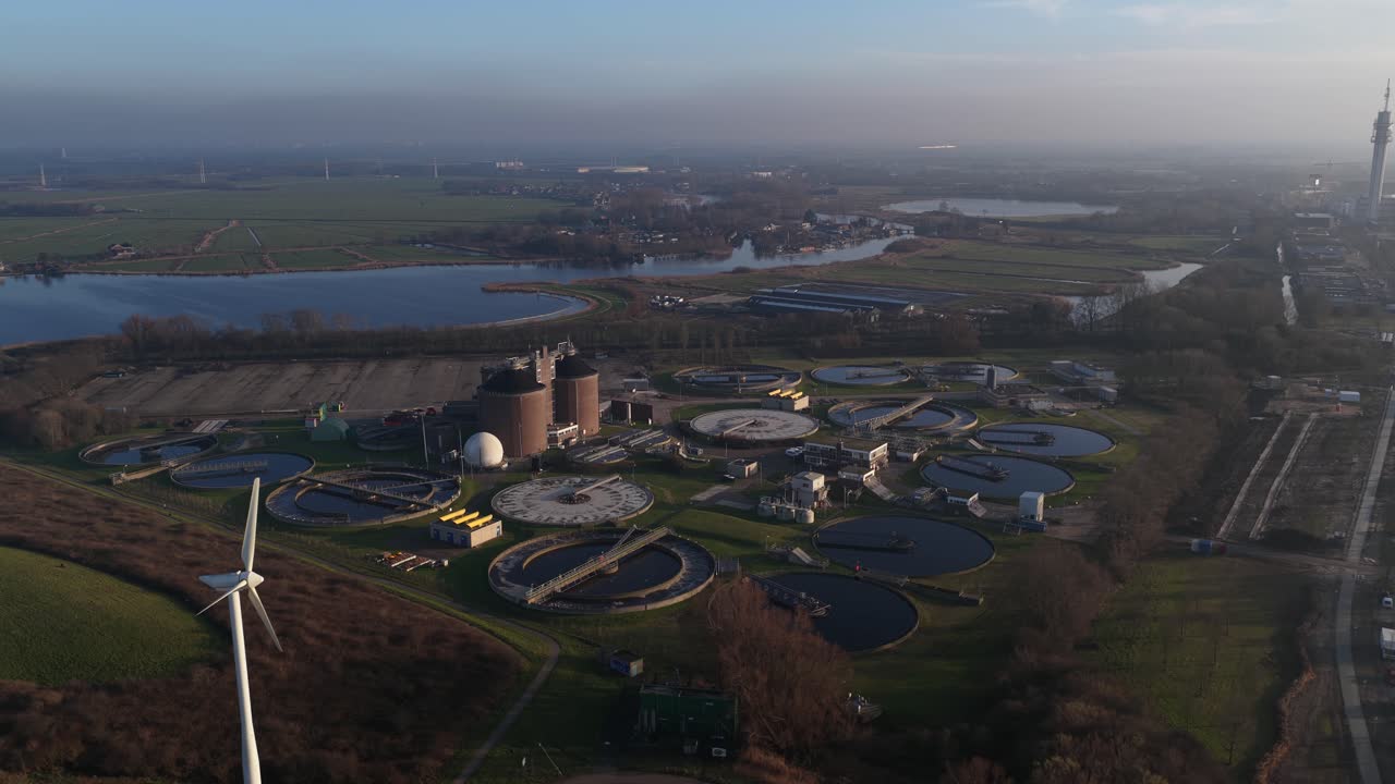 Aerial drone video of a wastewater and sewage treatment plant in Haarlem, Netherlands, showing water purification infrastructure, circular basins, environmental management, and urban sanitation system