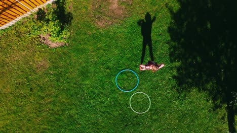 Girl-with-dress-playing-with-her-own-shadow-dancing-and-walking-away-drone-top-shot-with-long-shadow