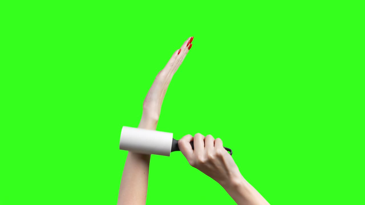 녹색 배경 에 옷 을 청소 하는 롤러 를 가진 여자 손 의 비디오