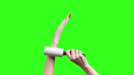 video of female hands with roller for cleaning clothes on green background