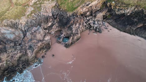 AERIAL:-Wide-circle-shot-of-large-blue-rockpool-with-seabirds,-Blue-Pool-Bay,-4k-Drone