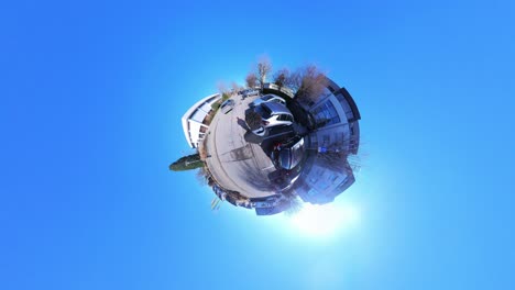 little tiny planet 360 small world view of a man walking past cars towards a church in 4k