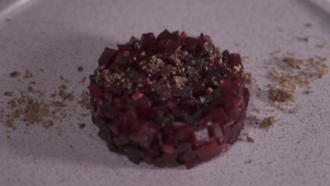 Close-up-of-chef-adding-fresh-herbs-on-top-of-fancy-vegan-Beet-tartare