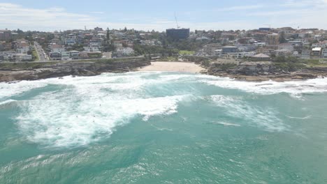 Surfers-Riding-Ocean-Swells-At-Tamarama-Beach-During-Summer---Cove-Beach-In-Tamarama,-NSW,-Australia