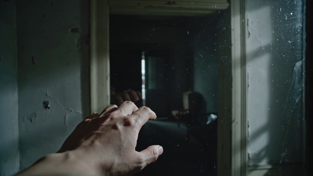Reaching adult right hand and bare forearm touching glassed window in dim hall, checking glass