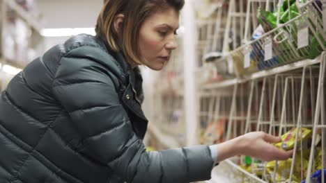 young woman shopping in grocery chosing products