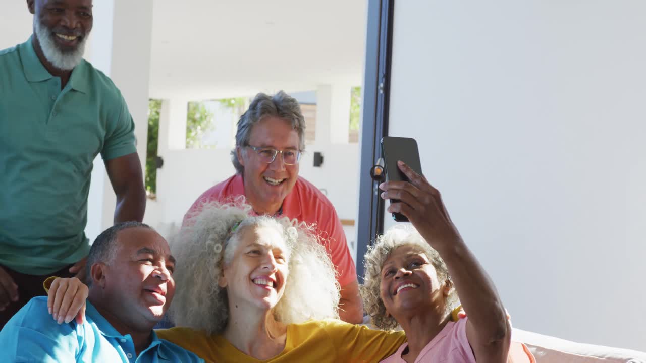 Happy senior diverse people taking selfie at retirement home