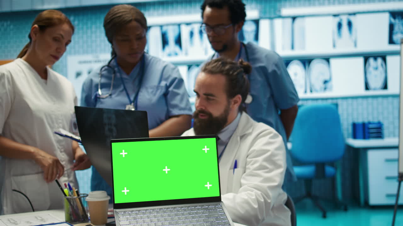Medical Team Analyzing X-ray with Green Screen Laptop