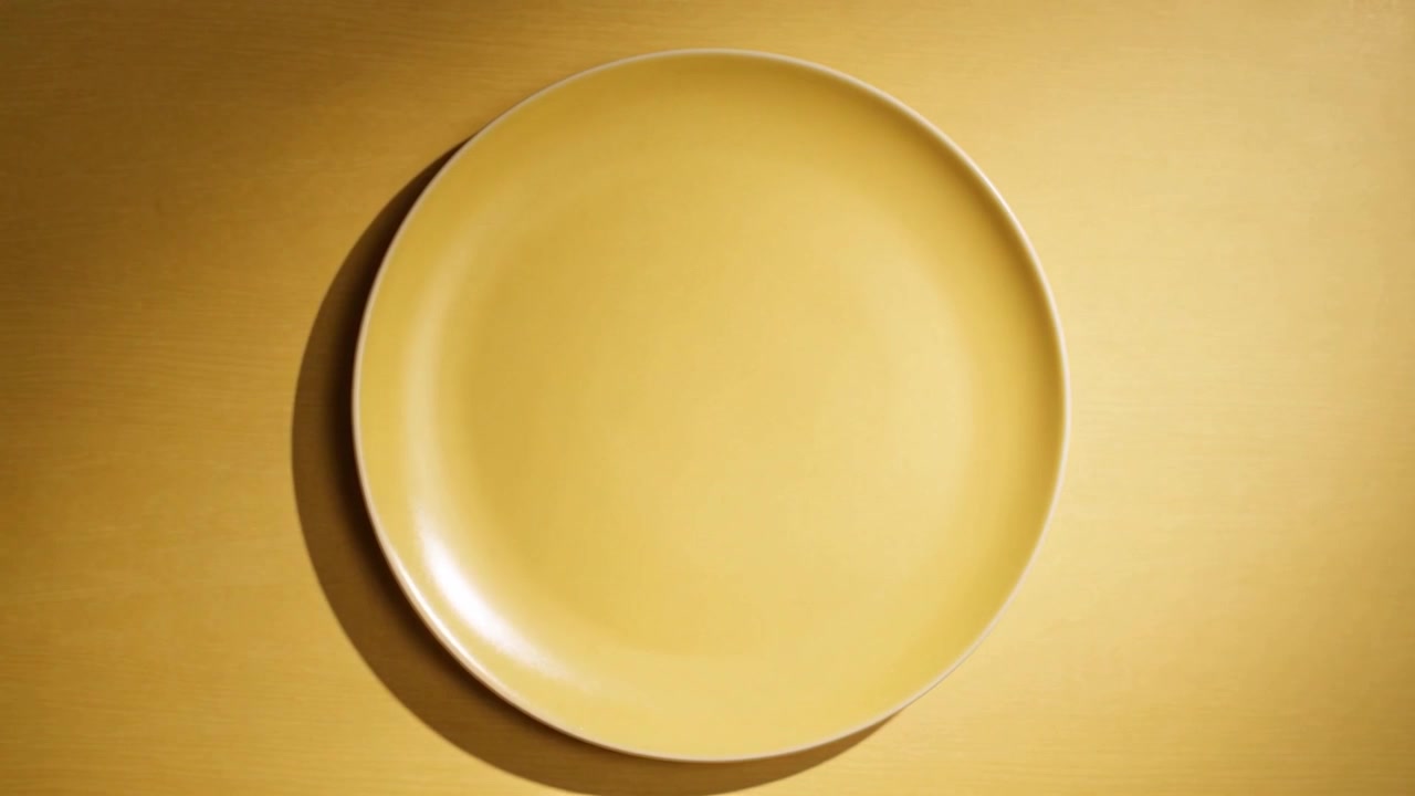 Showing golden plate shifting clockwise toward center on studio table after start, crescent shadow