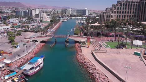 aerial view of eilat's hotel lagoon, canal, and marina with city and mountain backdrop