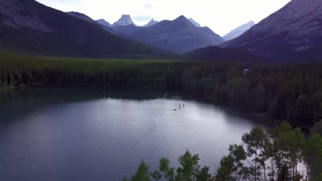 Barco-De-Tablas-De-Paddle-En-El-Estanque-En-Las-Montañas-Se-Acercó-A-Las-Montañas-Rocosas-De-Kananaskis,-Alberta,-Canadá