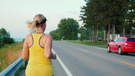 a young woman jogs along a typical us suburb steadicam follow shot