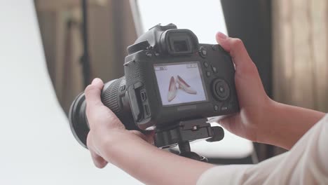 close up of camera's monitor showing photos of women's shoes in home studio