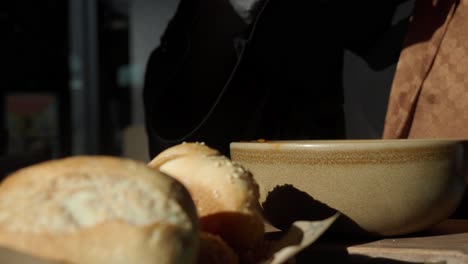 person eating soup with bread