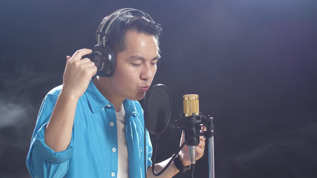 녹음 스튜디오 에서 마이크 로 노래 하는 남자