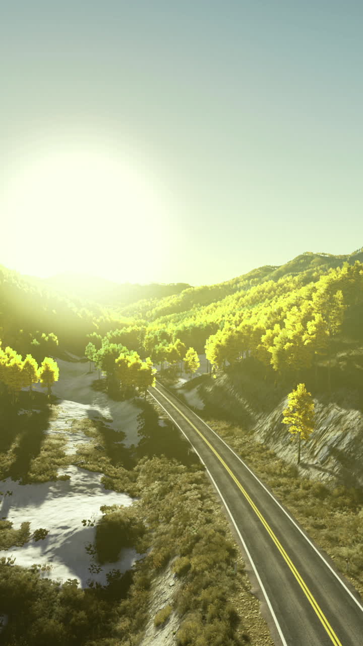 Sunrise over lush green hills and winding road in a tranquil landscape