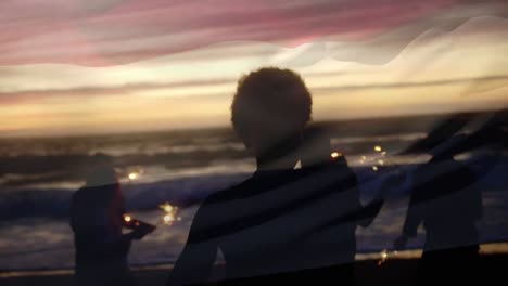 animation of waving flag of netherlands over group of friends having fun on the beach