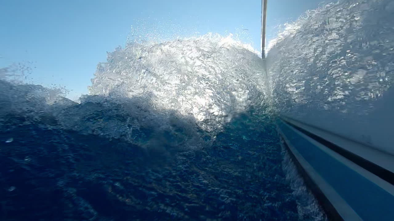 Low angle view of yacht's wake, port side view of the boat, slow motion.