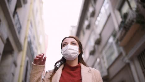 beautiful girl wearing protective medical mask and fashionable clothes stands at street