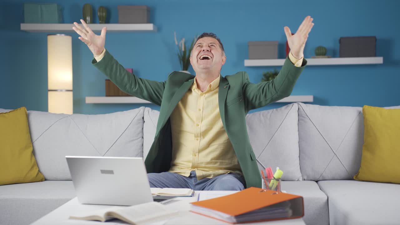 человек, работающий на дому, читает хорошие новости и чувствует себя счастливым.