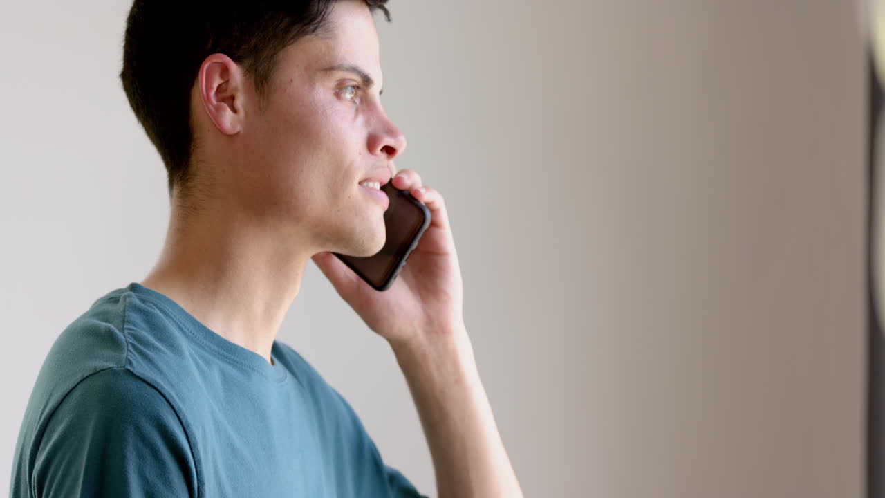 스마트폰으로 대화하는 두 인종의 남자가 거실에서 서서히 움직이고 있습니다.