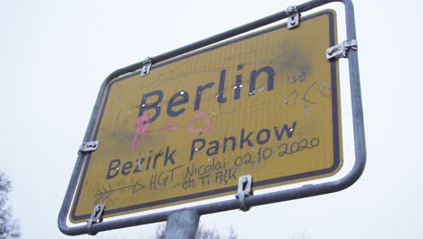 dirty berlin city sign on cloudy day in slow motion