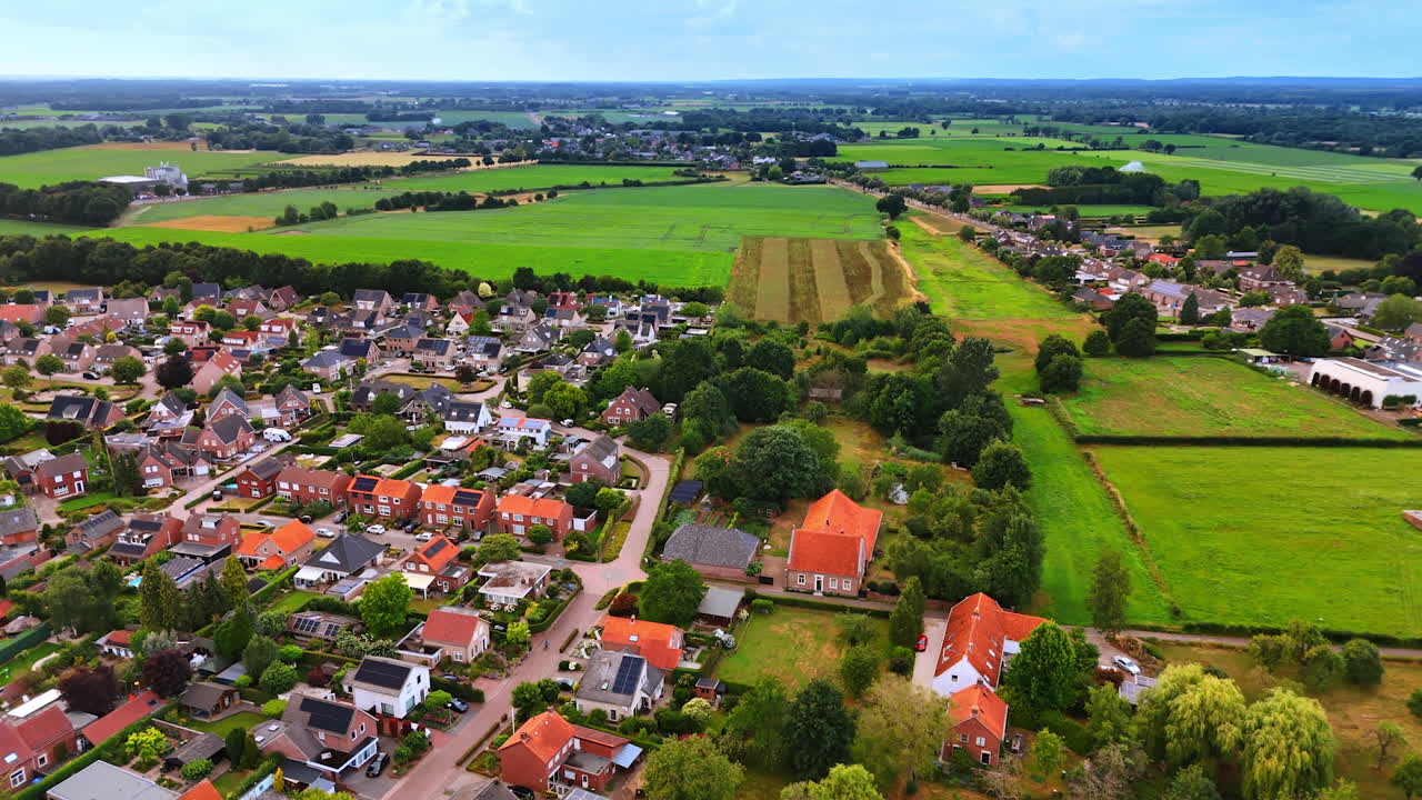 Drone photo of Dutch countryside with red rooftops and open green fields. Aerial drone photo of Dutch countryside with residential houses, red rooftops, and wide green fields