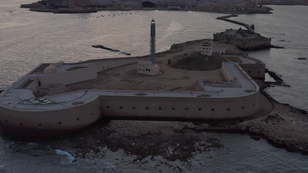Coastal city at sunset with a lighthouse
