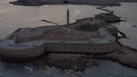 coastal city at sunset with a lighthouse