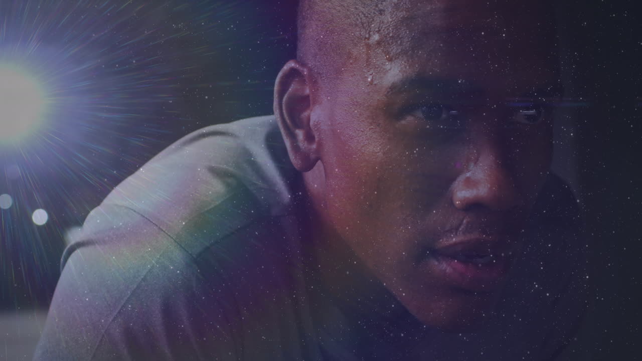 video compuesto digital del destello de la lente contra el primer plano de un hombre afroamericano en el gimnasio