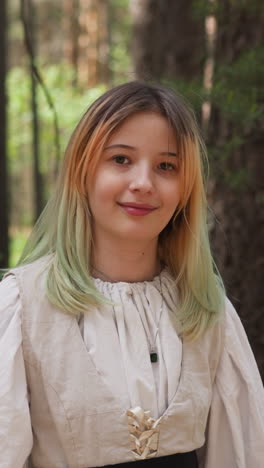 blonde girl smiles in medieval forest, close-up