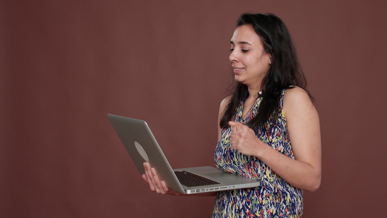 Indian adult using laptop to talk on online videocall conference