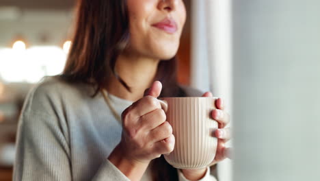 woman enjoying a hot beverage by the window