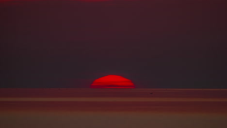 Toma-Estática-Del-Sol-Saliendo-Al-Amanecer-Sobre-El-Océano-Pacífico-A-Lo-Largo-Del-Colorido-Cielo-Rojo-Sobre-Las-Olas-Del-Mar-En-La-Mañana