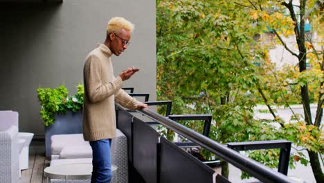 Side-view-of-young-black-businessman-talking-on-mobile-phone-in-office-4k