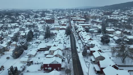 Snowy-american-town-in-winter-with-driving-cars-on-straight-main-street