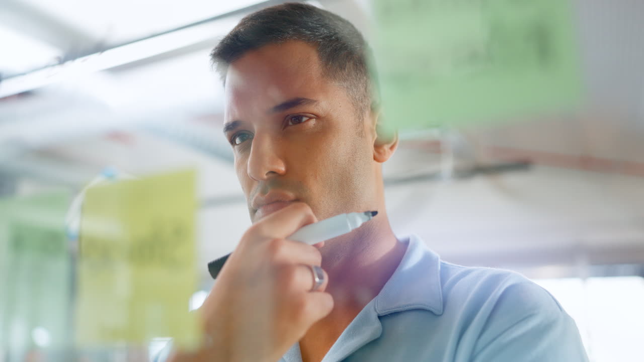 hombre concentrándose en notas adhesivas en la oficina