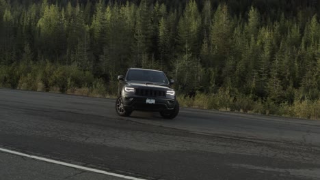 drone shoot of a grey jeep cherokee in 4k in a mountain road